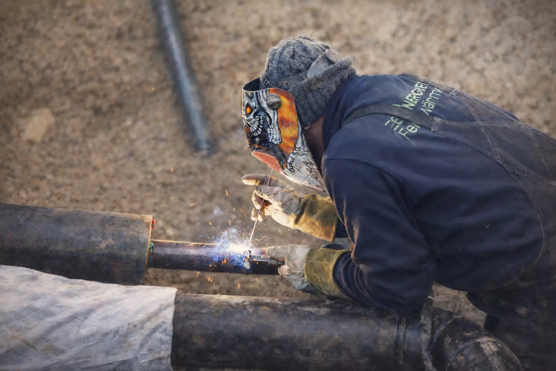 Nahaufnahme eines Schweisser beim Arbeiten im Graben