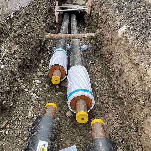 Nahaufnahme zwei grosser Rohrleitungen auf einer Fernwärmebaustelle